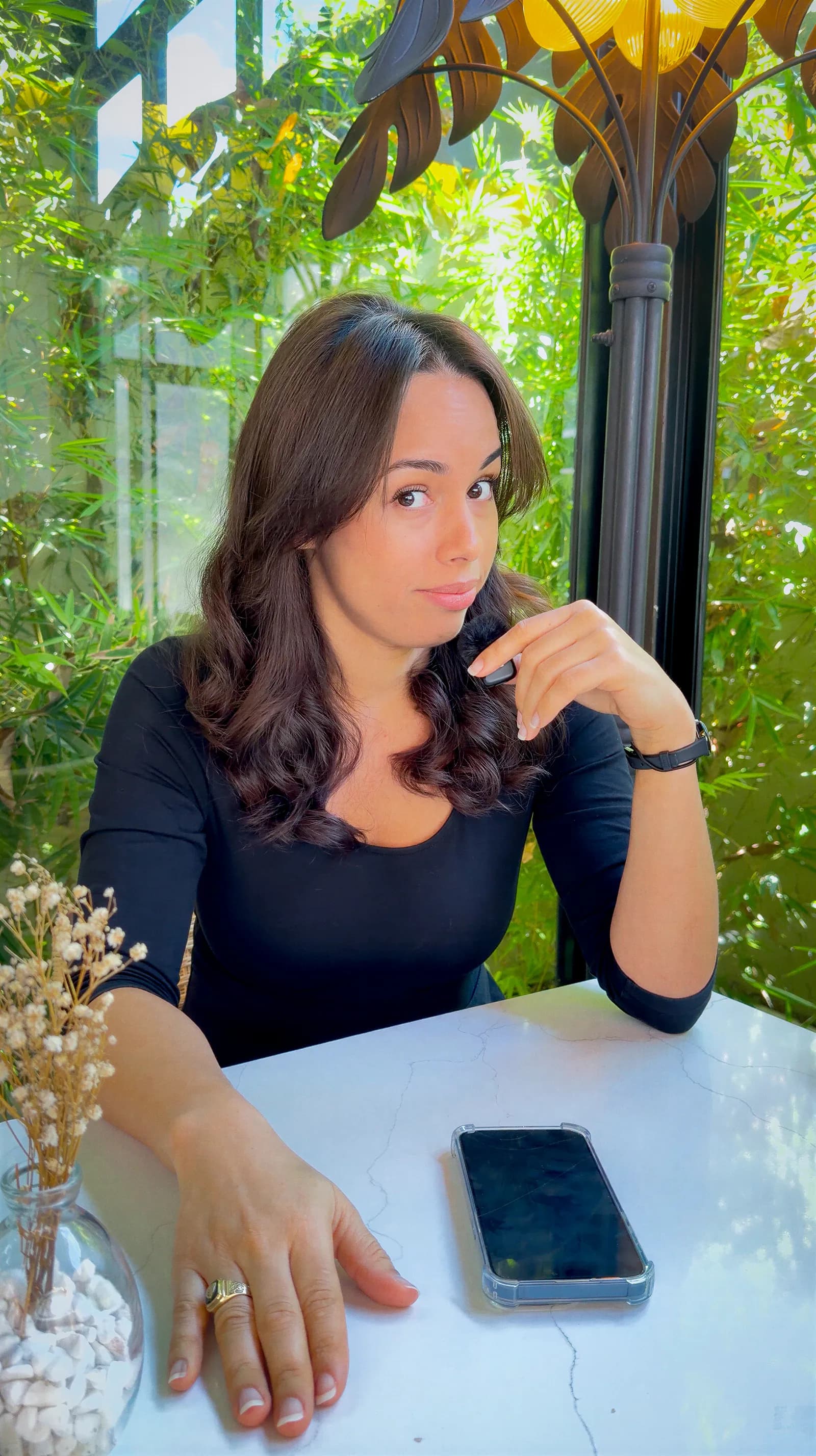 Daniela Sánchez sentada en una mesa en un espacio con plantas