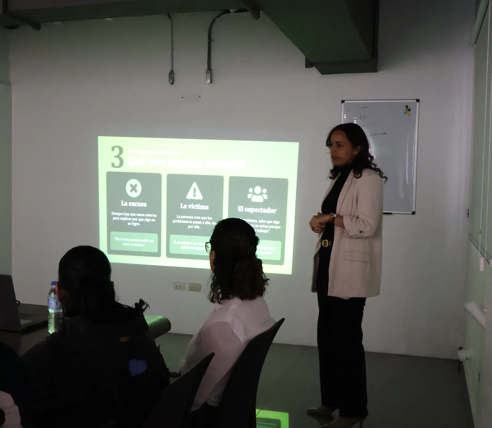 Daniela Sánchez dando un taller, vista desde detrás de las personas que asisten